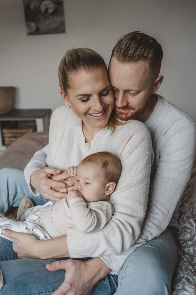 Mama und Papa kuscheln mit Baby